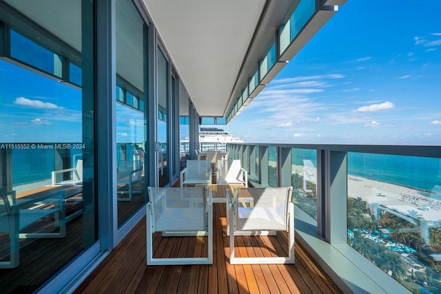 balcony featuring a water view and a beach view