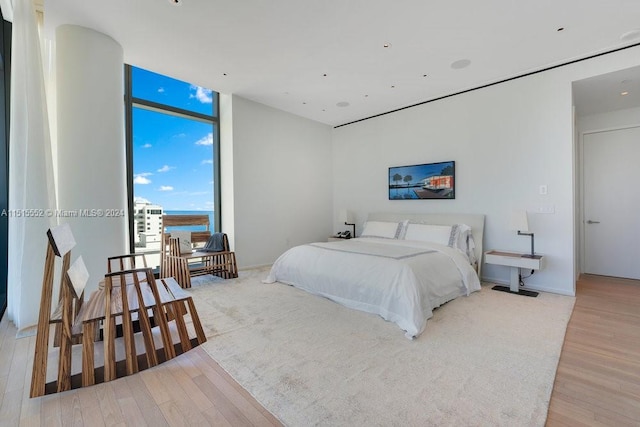 bedroom with light hardwood / wood-style flooring and floor to ceiling windows