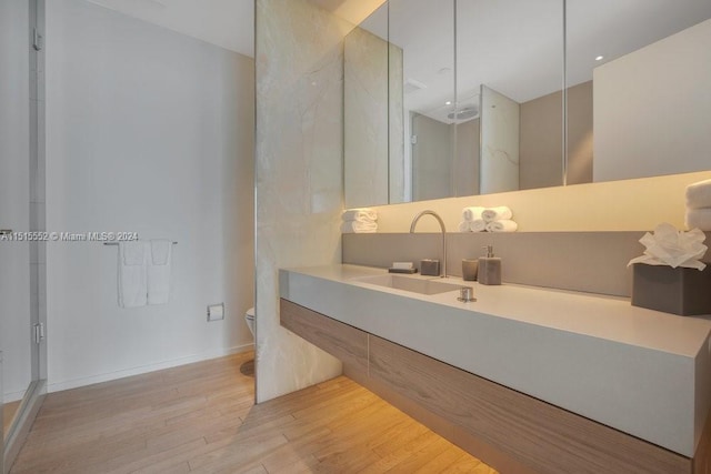 bathroom featuring vanity, toilet, hardwood / wood-style flooring, and a shower with shower door