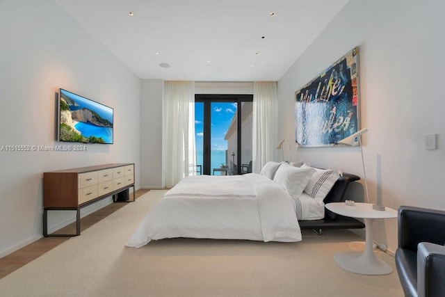 bedroom featuring access to exterior and light wood-type flooring