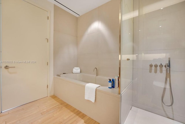 bathroom with plus walk in shower and hardwood / wood-style floors