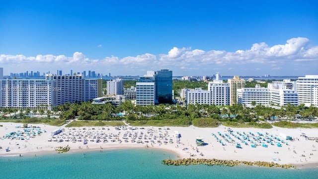 birds eye view of property featuring a beach view and a water view