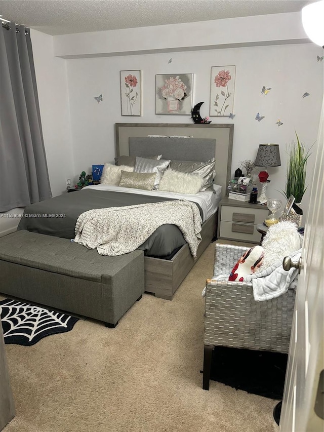 bedroom with a textured ceiling and light colored carpet