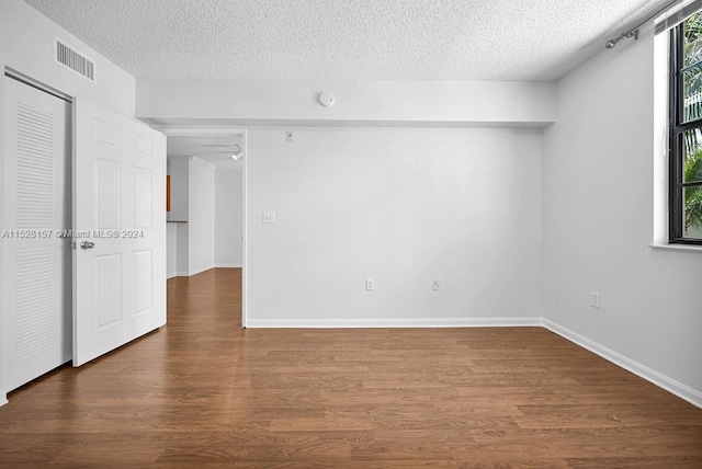 spare room with hardwood / wood-style flooring and a textured ceiling