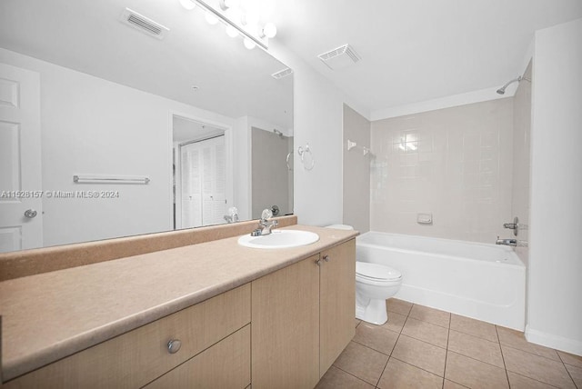 full bathroom featuring tile patterned floors, tiled shower / bath, toilet, and vanity