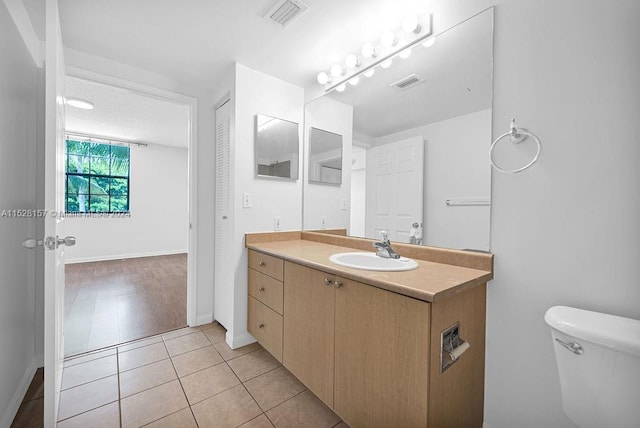 bathroom with wood-type flooring, toilet, and vanity