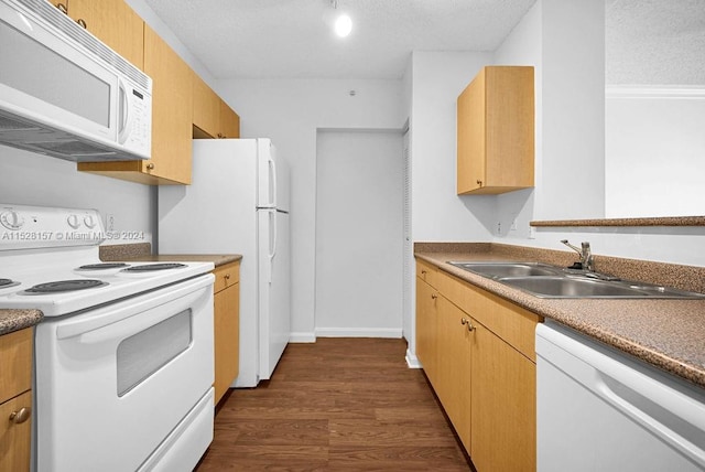 kitchen featuring white appliances, sink, light brown cabinets, dark wood-type flooring, and a textured ceiling