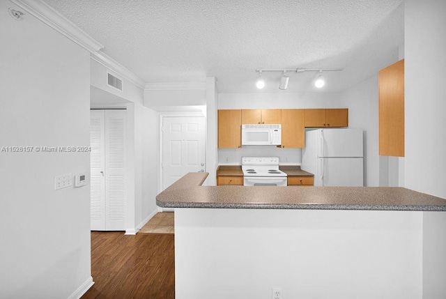 kitchen with dark wood-type flooring, white appliances, kitchen peninsula, and a textured ceiling