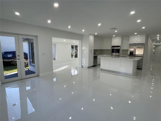 kitchen featuring white cabinetry, plenty of natural light, a kitchen island, and stainless steel appliances