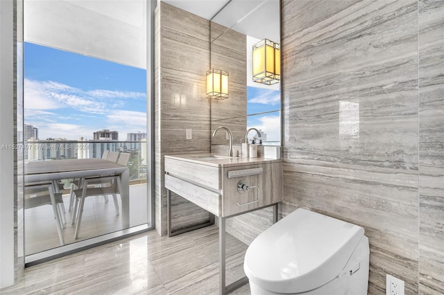 bathroom with vanity, plenty of natural light, tile flooring, and tile walls