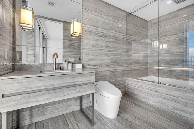 bathroom with tile walls, toilet, and oversized vanity