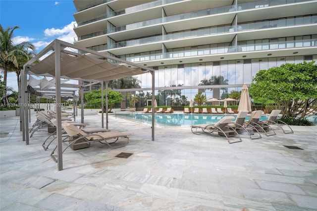 view of swimming pool featuring a patio area and a lanai