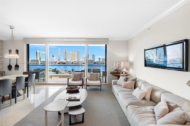 living room with a water view, crown molding, a notable chandelier, and a wealth of natural light