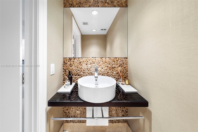 bathroom featuring tasteful backsplash and sink