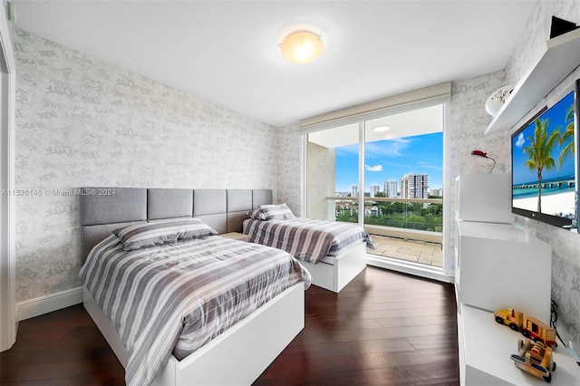 bedroom with access to outside and dark hardwood / wood-style floors