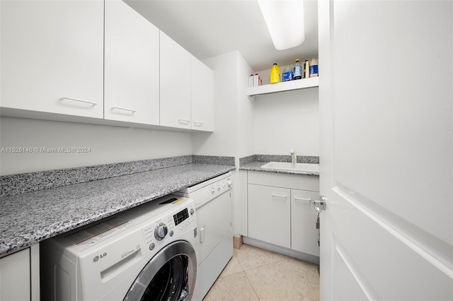 clothes washing area with separate washer and dryer, cabinets, light tile flooring, and sink