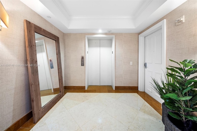 corridor featuring a tray ceiling, light tile floors, and elevator