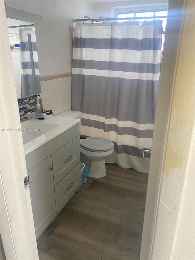 bathroom with tasteful backsplash, toilet, vanity, and hardwood / wood-style flooring