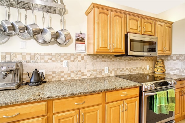 kitchen with tasteful backsplash, light stone countertops, and stainless steel appliances