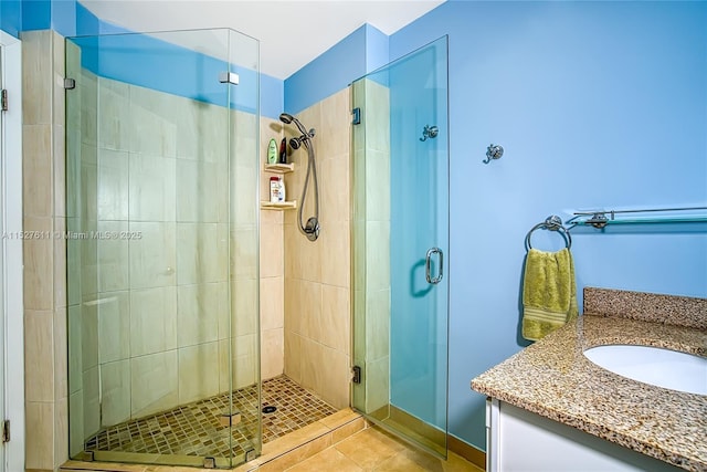 bathroom with walk in shower, vanity, and tile patterned flooring