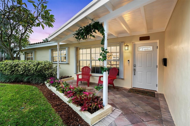 exterior entry at dusk featuring a porch