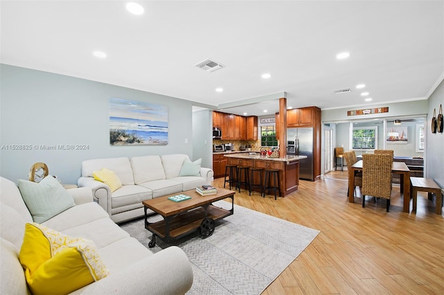 living room featuring light hardwood / wood-style floors and ornamental molding