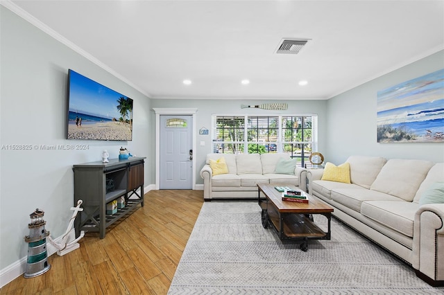 living room with crown molding and light hardwood / wood-style floors