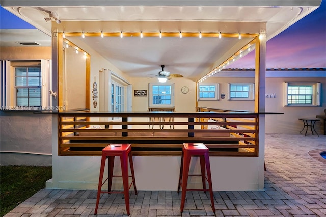 patio terrace at dusk featuring ceiling fan