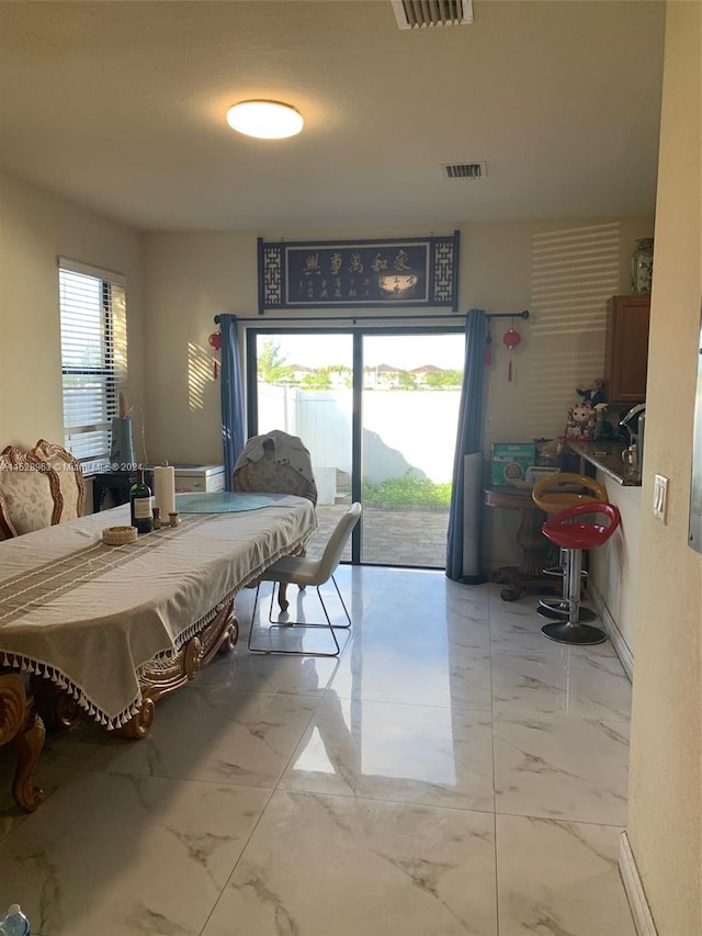 bedroom featuring multiple windows, access to exterior, and light tile flooring