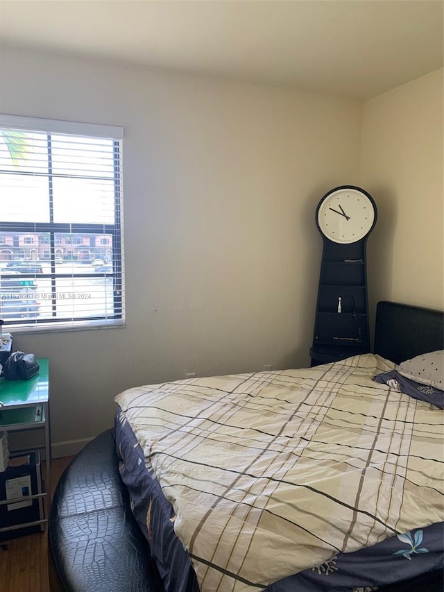 bedroom with dark hardwood / wood-style flooring and multiple windows