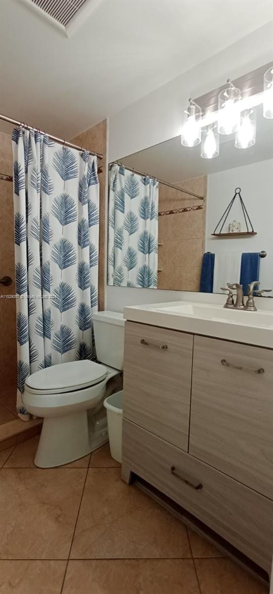 bathroom with toilet, tile flooring, and vanity