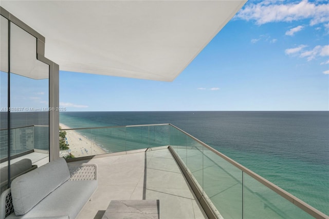 balcony featuring a water view and a beach view