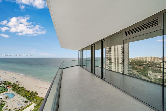 balcony featuring a water view and a beach view