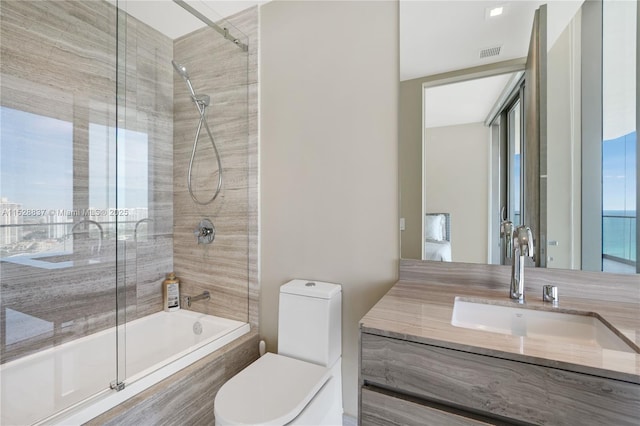 full bathroom featuring vanity, shower / bath combination with glass door, toilet, and a water view