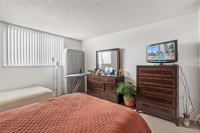 bedroom with light carpet and a textured ceiling