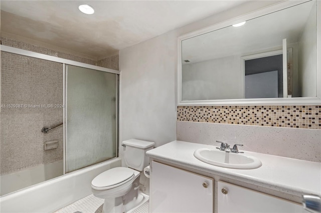 full bathroom with toilet, tile floors, oversized vanity, and bath / shower combo with glass door