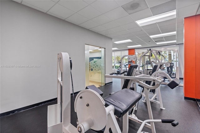 workout area with a drop ceiling and a wealth of natural light