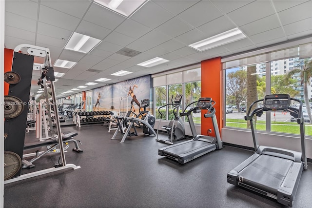 gym with plenty of natural light and a paneled ceiling