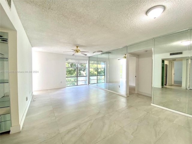 unfurnished room with light tile floors, a textured ceiling, and ceiling fan