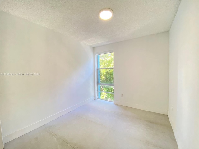 unfurnished room featuring a textured ceiling