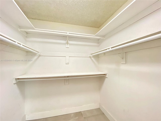 walk in closet featuring light tile floors