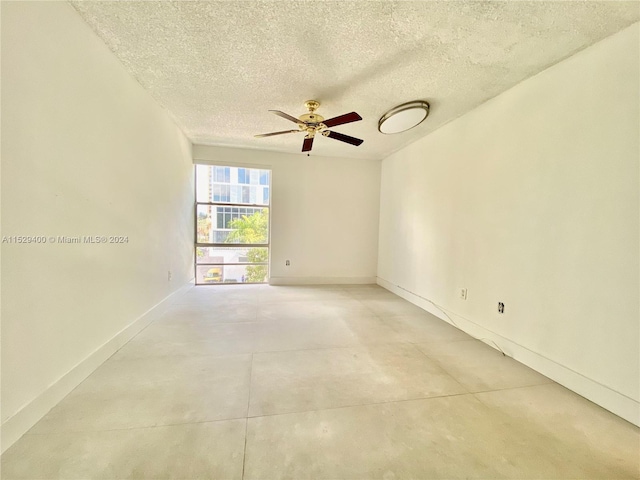 unfurnished room with ceiling fan and a textured ceiling