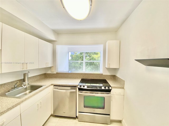 kitchen with sink, light tile floors, white cabinets, stainless steel dishwasher, and gas range