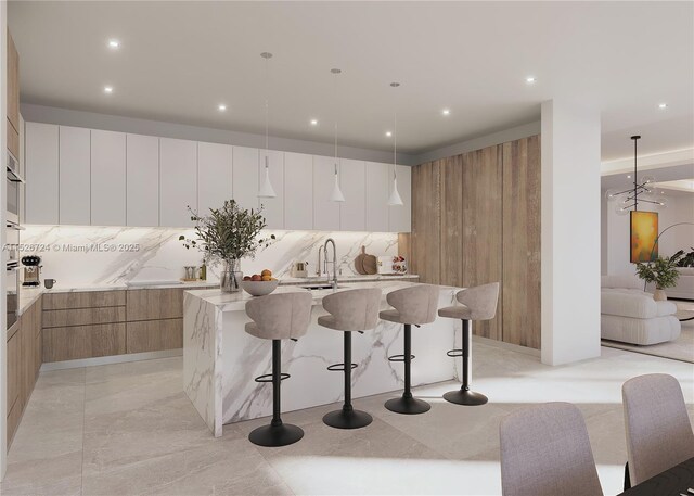 kitchen with pendant lighting, oven, a water view, and a raised ceiling