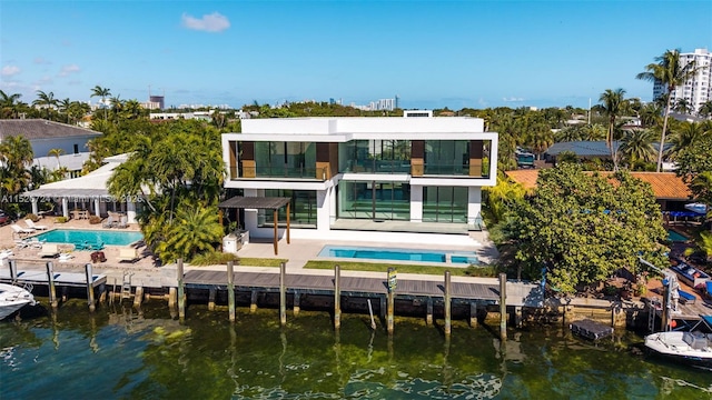 rear view of house with a fenced in pool, a water view, a patio, and a balcony