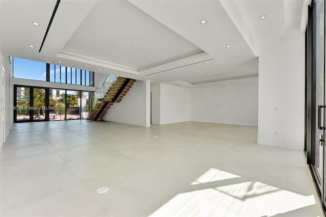 unfurnished living room featuring a tray ceiling and french doors