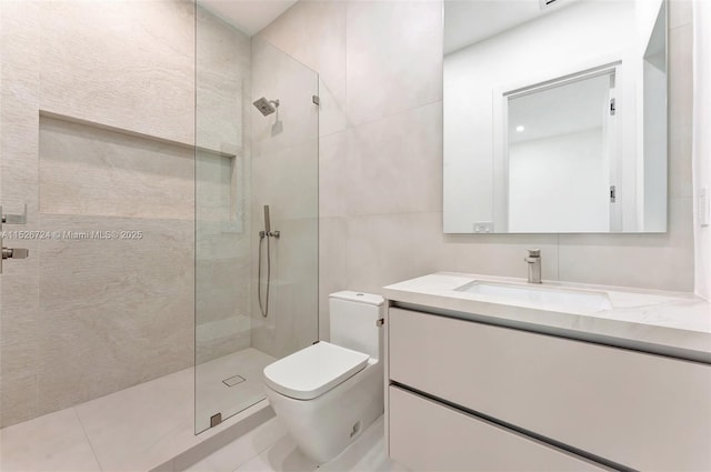 bathroom with toilet, tiled shower, tile walls, and vanity