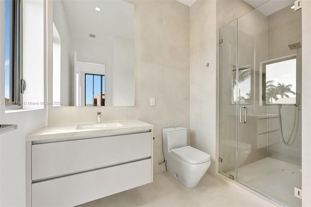 bathroom featuring toilet, tile patterned floors, an enclosed shower, and vanity