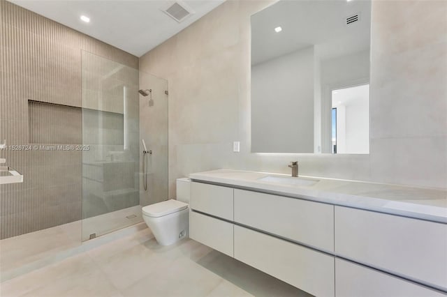 bathroom with vanity, a tile shower, toilet, and tile patterned floors