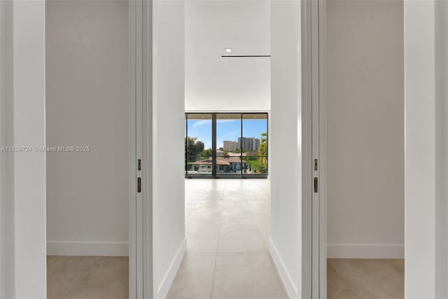 corridor featuring light tile patterned floors and floor to ceiling windows